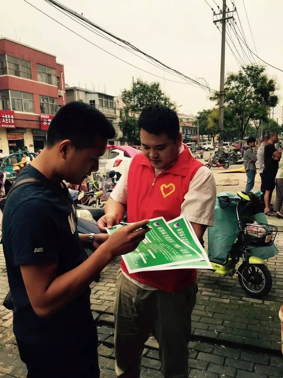 红马甲志愿者在路口执勤,志愿者红马甲穿行在大街小巷